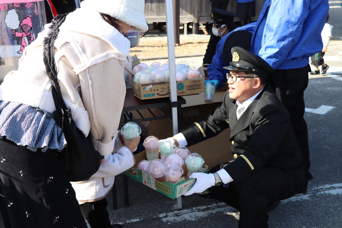 来場した子どもにわたがしを配布する消防団員
