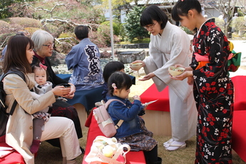 庭園の立礼席でお抹茶を楽しむ家族連れ