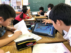 タブレットを使って学習する児童たち