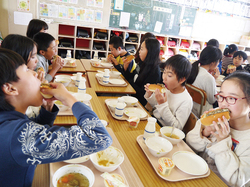 給食を食べる児童ら