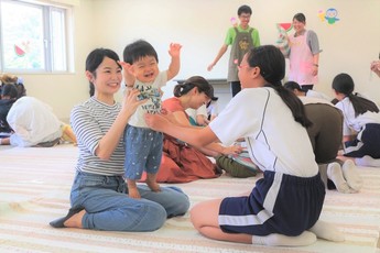 赤ちゃんとふれあう中学生の写真