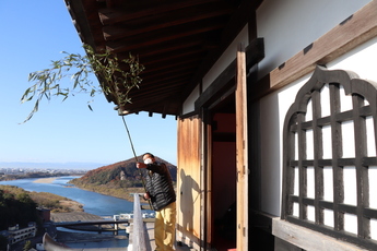 竹ほうきですす払いを行う職員