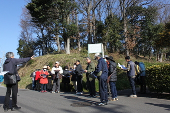 坊の塚古墳の前で赤塚理事長から説明を受ける参加者たち