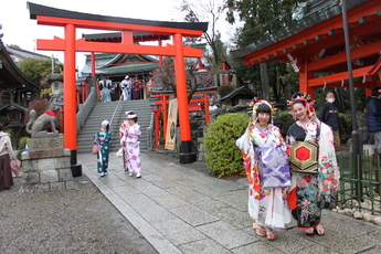 鳥居前で狐のポーズをとる花魁姿の参加者