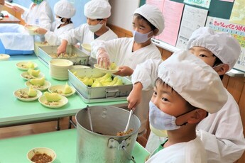 給食のメロンを配膳する児童たち