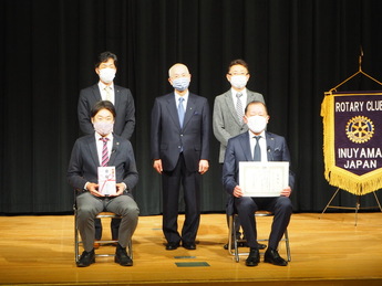 壇上に並ぶ市長とロータリークラブの男性4人