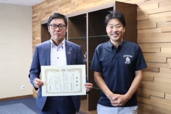 感謝状を手に持って田中社長と市長が記念写真