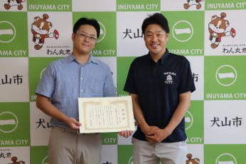 感謝状を手に持って奥井翔太さんと市長が記念写真
