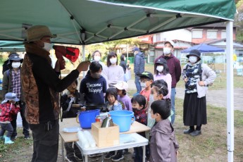 栗栖に生えているお茶の説明をしている様子