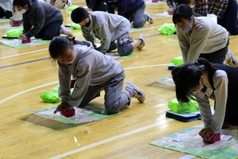 トレーニングキットで胸骨圧迫の練習をする子どもたち