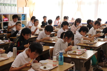 給食を食べる児童らの写真