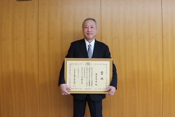 表彰状を手にする小松屋商店の倉地秀幸さん