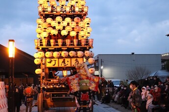 金襦袢を背中に背負い梃子に肩車される子ども