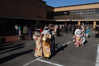 集いの会場外で旧友と話す参加者