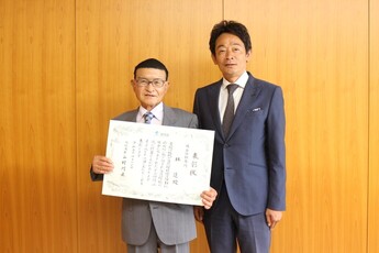 表彰状を手にする林進さん(左)と原市長(右)の写真