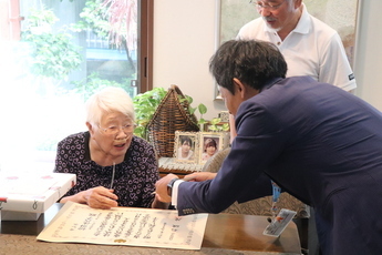お祝いの品を受け取る松田さん